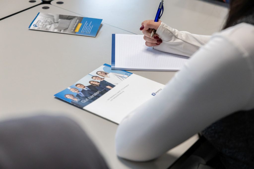 Person schaut über PORTICA Broschüren