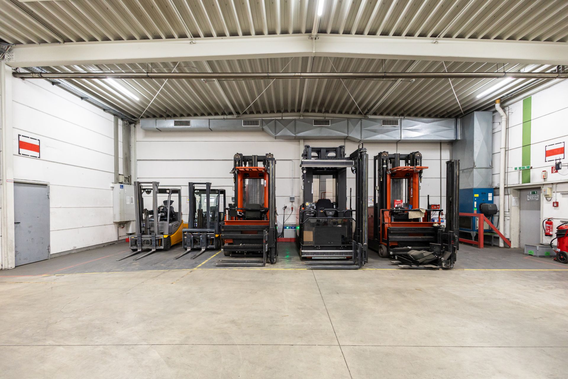 Industriehalle mit mehreren Gabelstaplern und Flurförderzeugen für nachhaltigen Warenumschlag